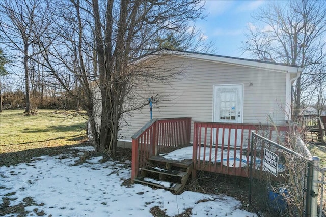 snow covered house featuring a wooden deck