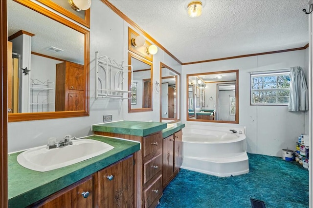 bathroom with ornamental molding, vanity, a textured ceiling, and a tub to relax in