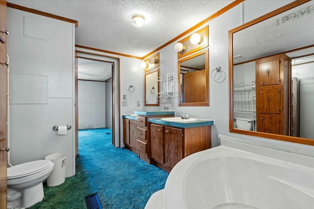 bathroom featuring toilet, a textured ceiling, ornamental molding, vanity, and a bathing tub