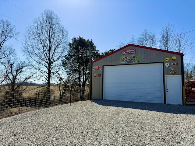 detached garage featuring fence