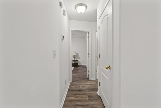 corridor featuring dark hardwood / wood-style floors and a textured ceiling