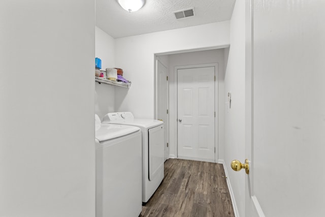 laundry area featuring washer and dryer, dark wood-type flooring, and a textured ceiling