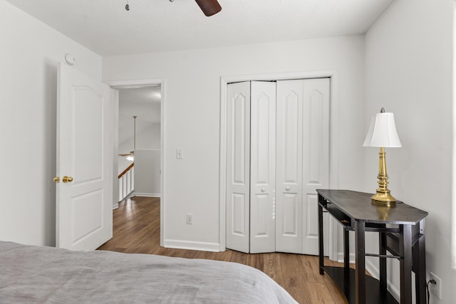 bedroom featuring ceiling fan, wood-type flooring, and a closet