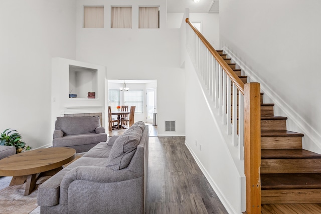 interior space with a towering ceiling, hardwood / wood-style floors, and a notable chandelier