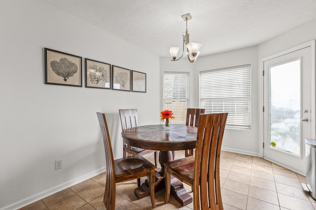 dining area featuring a wealth of natural light, a notable chandelier, and light tile patterned floors