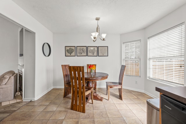 tiled dining area with a textured ceiling and a notable chandelier