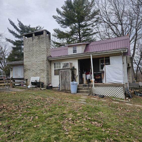 rear view of property with a porch and a lawn