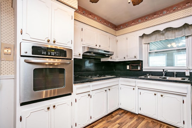 kitchen with sink, gas stovetop, white cabinets, and stainless steel oven