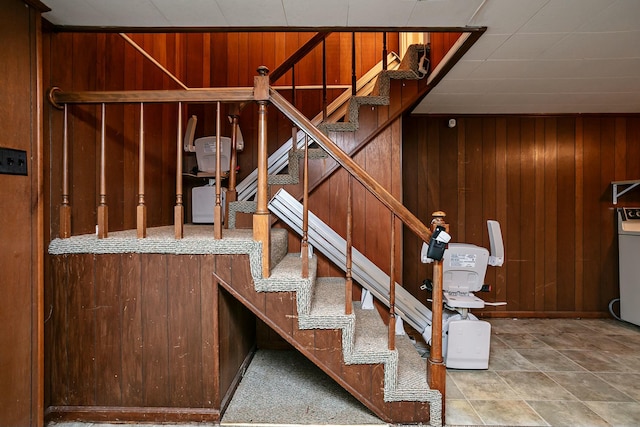 staircase featuring wood walls