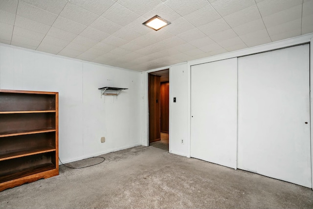 unfurnished bedroom featuring light colored carpet and a closet