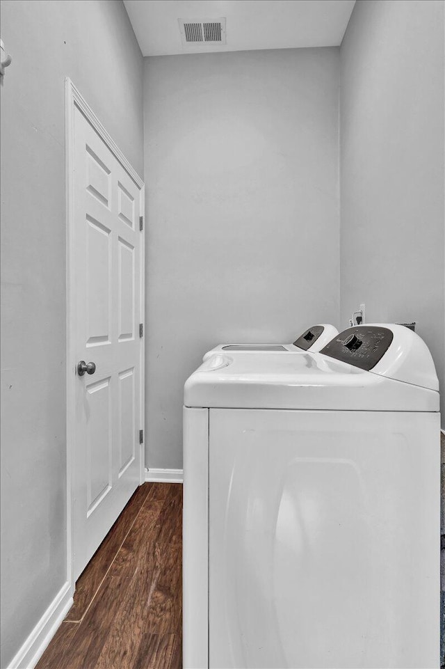 washroom featuring washing machine and dryer and dark hardwood / wood-style floors