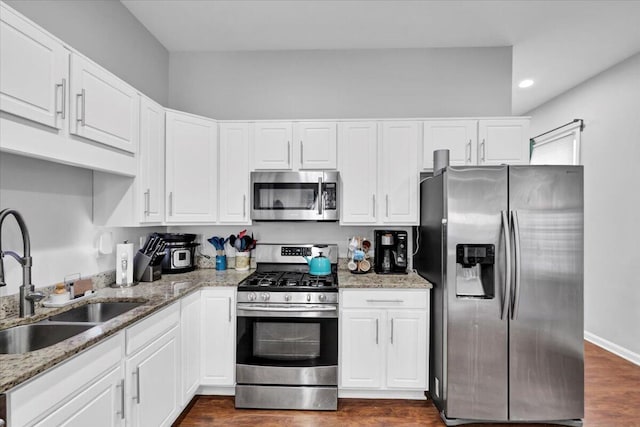 kitchen featuring sink, stone counters, appliances with stainless steel finishes, white cabinets, and dark hardwood / wood-style flooring