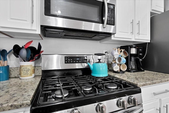 kitchen featuring light stone countertops, white cabinets, and appliances with stainless steel finishes