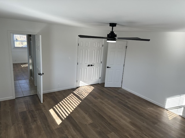 unfurnished bedroom featuring dark hardwood / wood-style floors, ceiling fan, and a closet