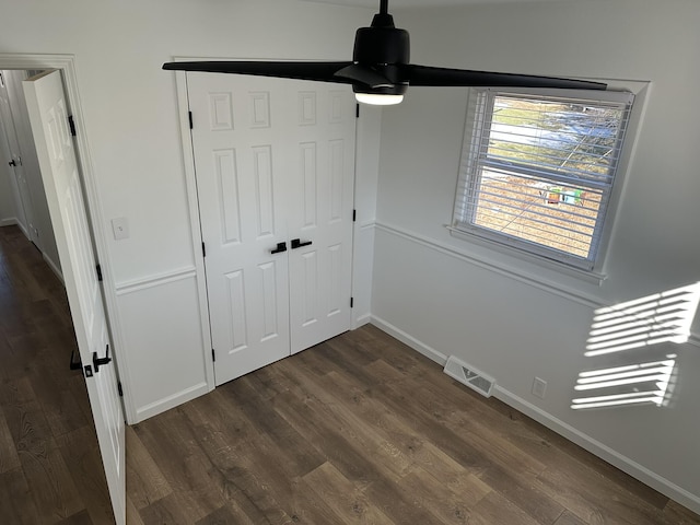 unfurnished bedroom with dark hardwood / wood-style flooring and a closet