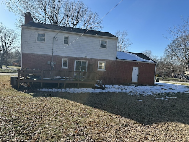 back of property featuring a wooden deck and a lawn