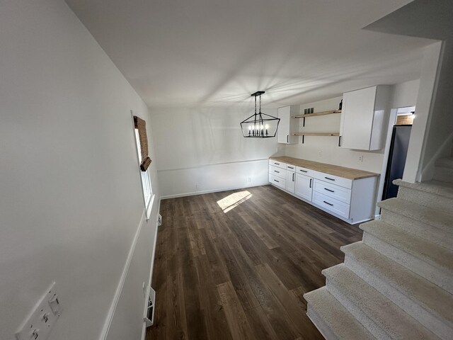 unfurnished living room featuring dark wood-type flooring and a fireplace