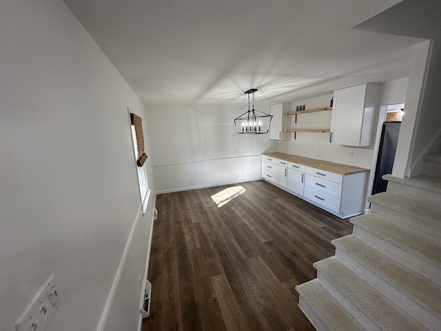 kitchen featuring pendant lighting, dark hardwood / wood-style floors, a chandelier, and white cabinets