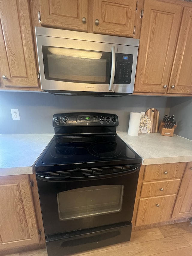 kitchen featuring electric range and light hardwood / wood-style floors