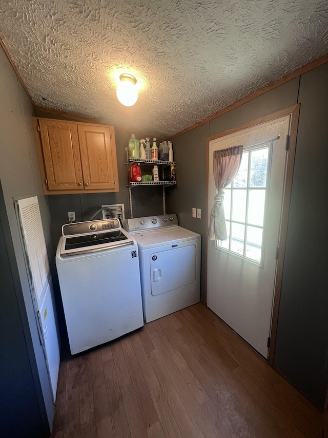 washroom with hardwood / wood-style flooring, cabinets, washer and clothes dryer, and a textured ceiling