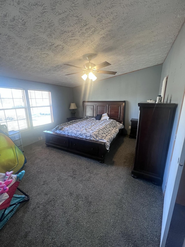 bedroom featuring ceiling fan, dark carpet, and a textured ceiling