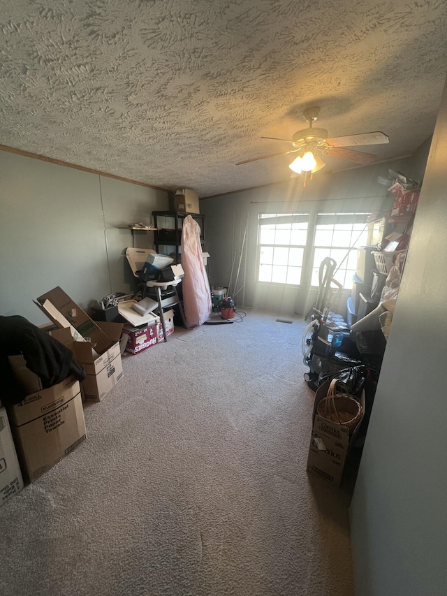 interior space with ceiling fan, carpet, and a textured ceiling