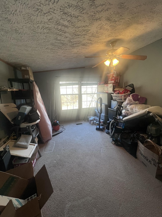 bedroom with a textured ceiling, ceiling fan, and carpet flooring