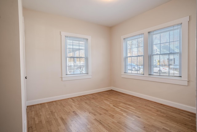 empty room with a healthy amount of sunlight and light hardwood / wood-style floors