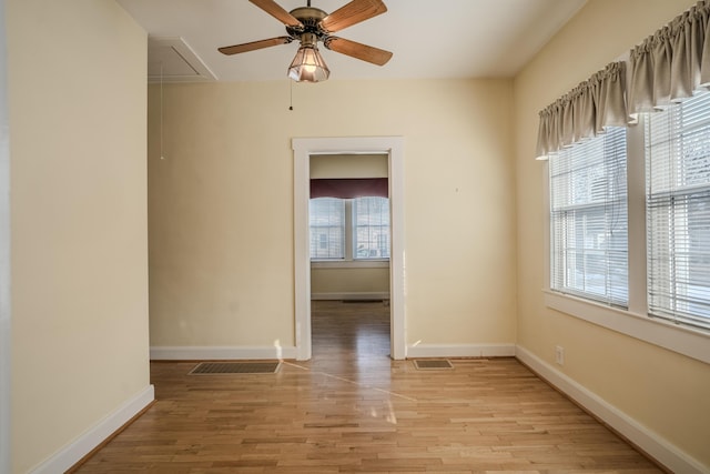 empty room with ceiling fan and light hardwood / wood-style flooring