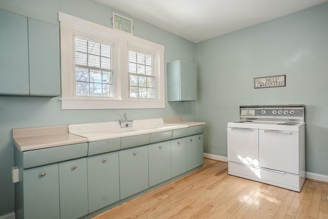 laundry area with sink and light hardwood / wood-style floors