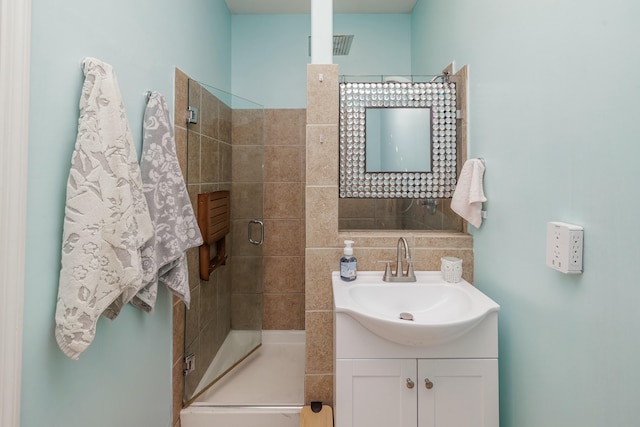 bathroom featuring vanity and a shower with shower door