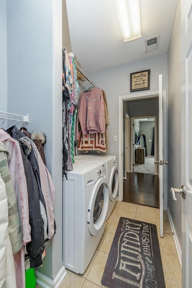 laundry room featuring washer and dryer and light tile patterned flooring