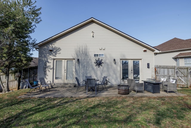 rear view of property featuring french doors, a yard, a patio area, and a fire pit