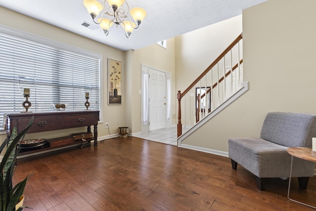 foyer featuring a notable chandelier, hardwood / wood-style flooring, and a textured ceiling