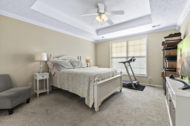 bedroom featuring crown molding, ceiling fan, carpet flooring, a tray ceiling, and a textured ceiling