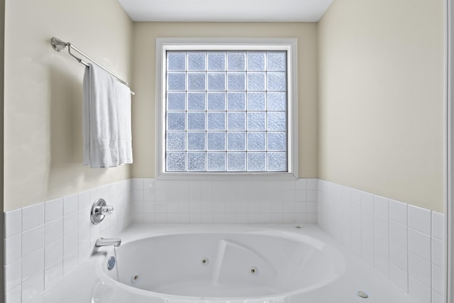 bathroom with a tub to relax in and a healthy amount of sunlight