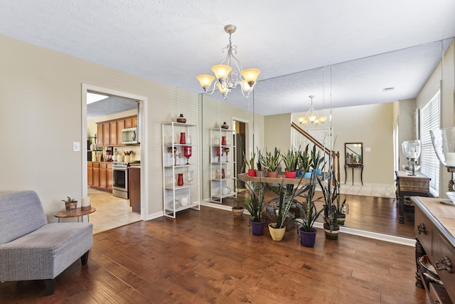 dining space with hardwood / wood-style flooring, a textured ceiling, and a chandelier