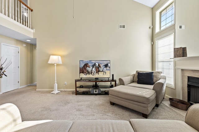 living room with a high ceiling and carpet flooring