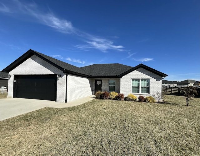 ranch-style home featuring a garage and a front lawn