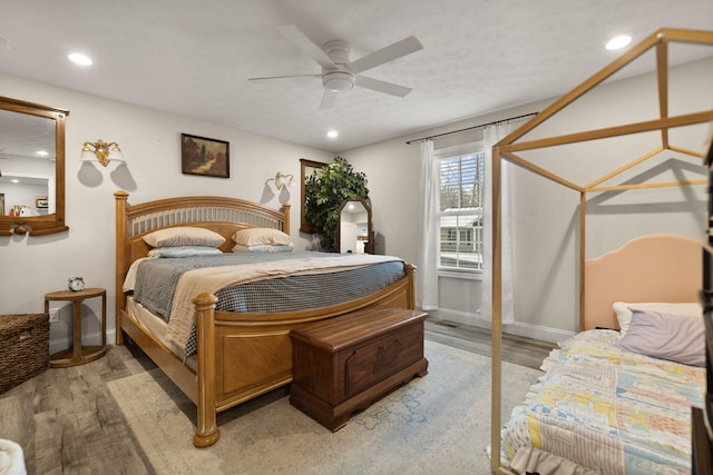 bedroom with a textured ceiling, ceiling fan, and light wood-type flooring