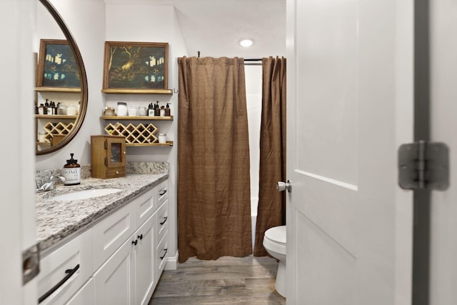 bathroom with hardwood / wood-style flooring, vanity, and toilet