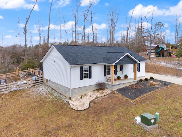 view of front of home with a playground, a front yard, and covered porch