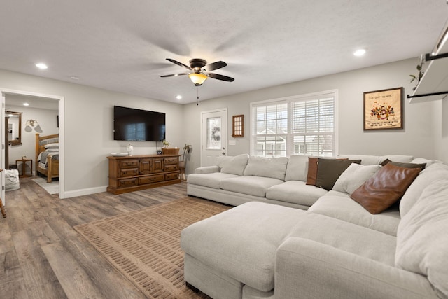 living room featuring hardwood / wood-style flooring, a textured ceiling, and ceiling fan