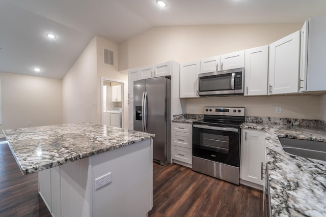 kitchen featuring white cabinetry, lofted ceiling, appliances with stainless steel finishes, and a center island