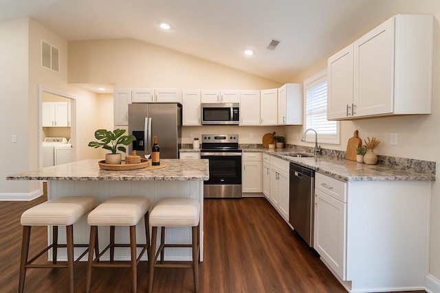 2053 Partridge Way, Richmond, KY 40475 - kitchen featuring stainless steel appliances, washing machine and clothes dryer, a sink, dark wood-style flooring, and a breakfast bar area