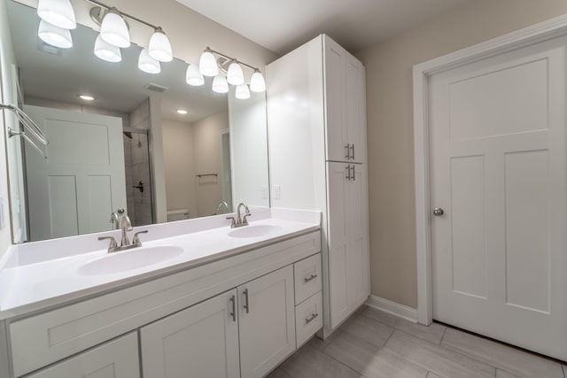 bathroom with vanity, a shower with shower door, and toilet