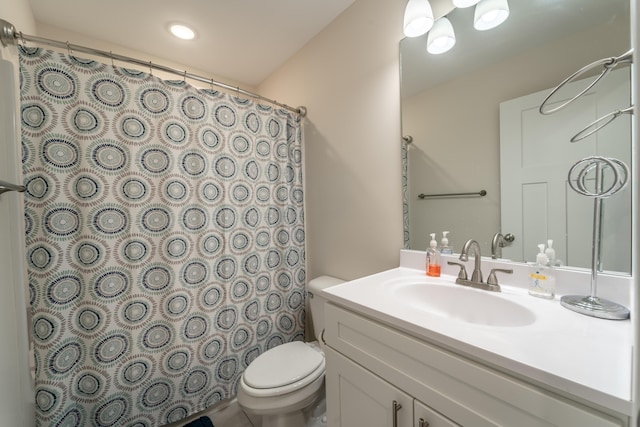 bathroom with walk in shower, vanity, and toilet