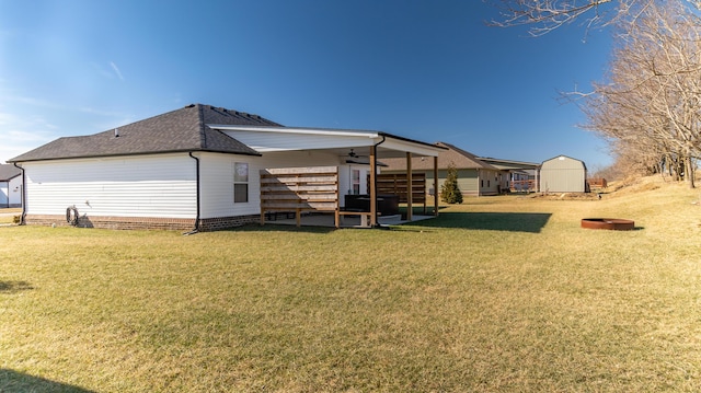 rear view of house featuring a shed and a lawn