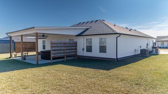 rear view of house with cooling unit, a yard, a patio area, and ceiling fan