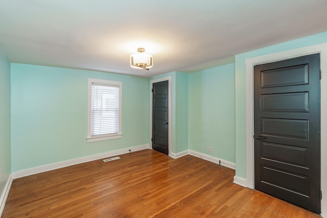 spare room featuring wood-type flooring